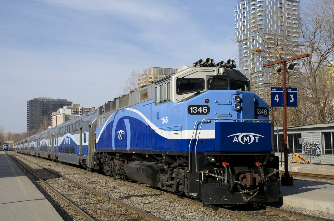 AMT 1346 is at the head of a set of multilevel cars in downtown Montreal during the morning rush hour.