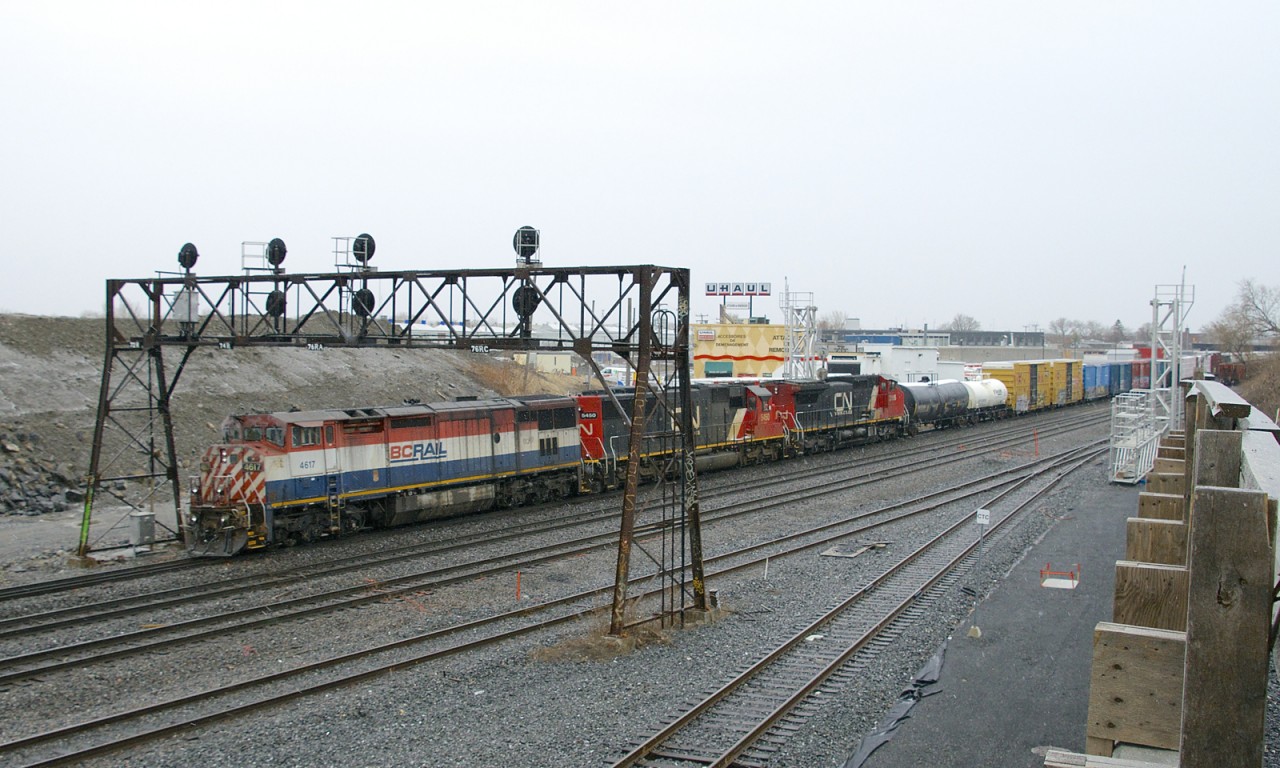 A very late CN 310 ducks under a vintage signal bridge that goes over CN's Montreal Sub at Turcot West that will not be in use for much longer, with its replacement already on site at the right. Power is BCOL 4617, CN 5450 & CN 2195.