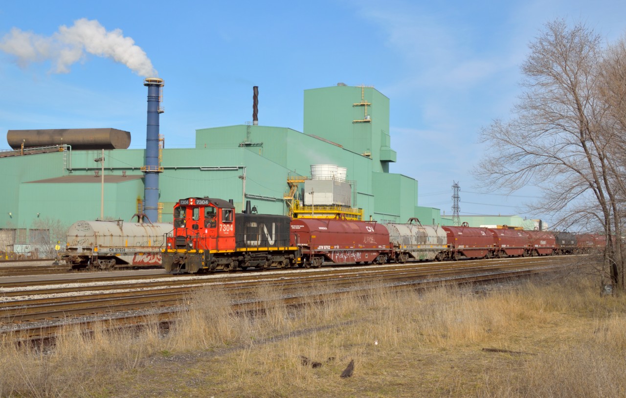 Dwarfed by the towering green Dofasco buildings, the venerable SW1200 shoves a cut of cars back towards the steel centre building for loading.  CN 7304 is one of only three SW1200's on the CN system; the other two reside in Mac Yard.