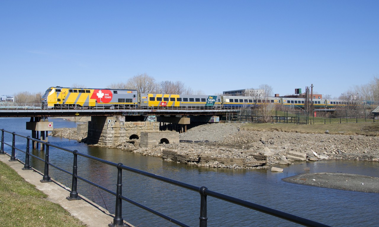 P42DC VIA 916 and LRC coach VIA 3351 are both wrapped for VIA Rail's 40th anniversary as they bring up the front of VIA 635, seen crossing the Lachine Canal.