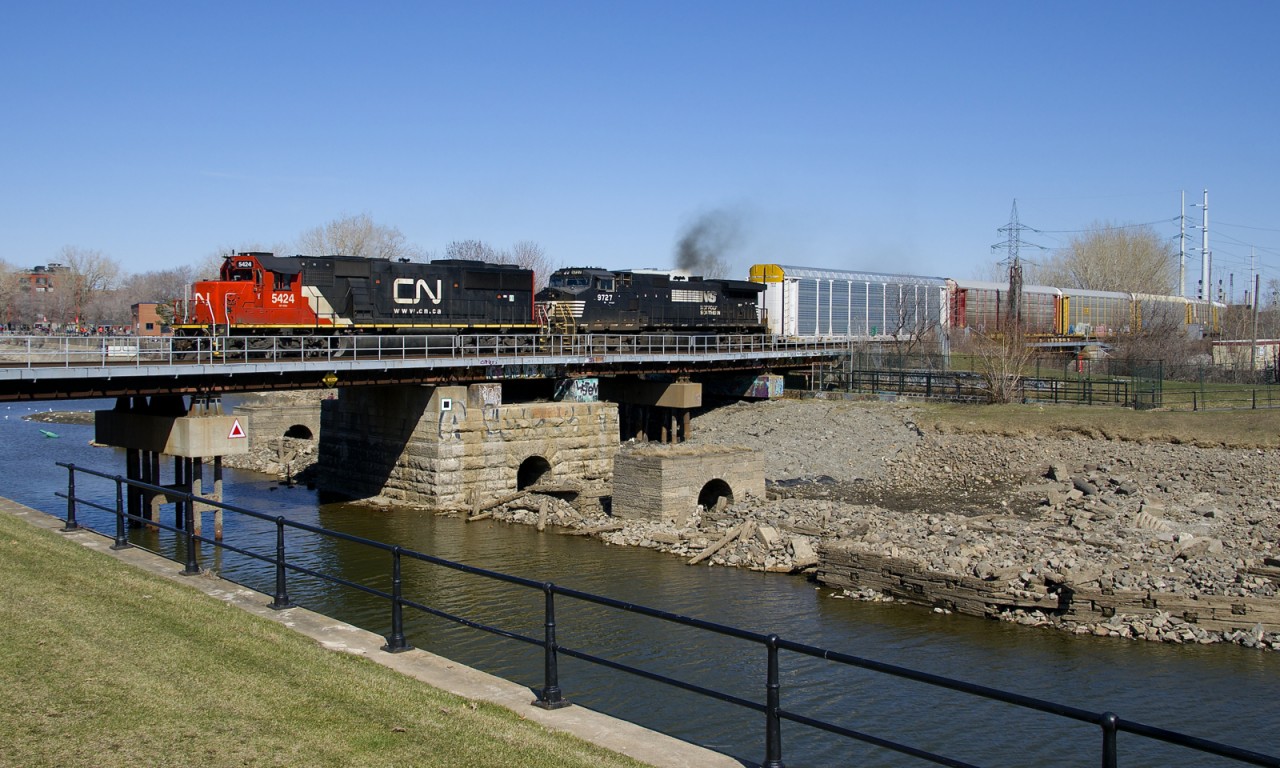 CN 5424 and smokey NS 9727 lead CN 401 over the Lachine Canal on a spring afternoon in Montreal (finally!). At the head end are loaded autoracks as always.