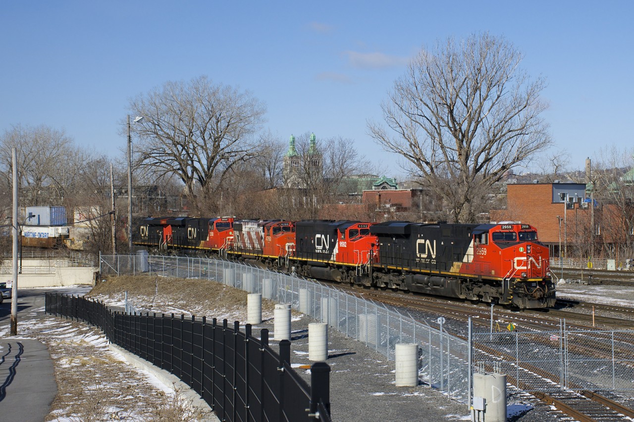 CN 120 has two geeps trailing (CN 9592 & CN 4760), along with the usual complement of GE power (CN 2959 leading, CN 2930 and CN 2911 fourth and fifth and CN 2965 mid-train). It is passing the railfans park beside the Pointe St-Charles Yard.