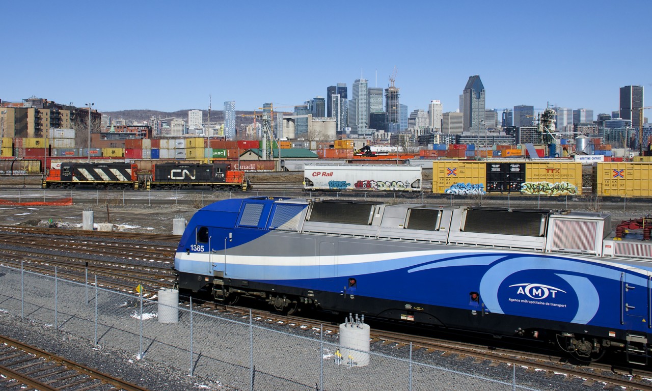 ALP-45DP AMT 1365 is doing some switching in the RTM's Maintenance Centre as GP9's CN 7726 & CN 4135 switch the parallel CN Pointe St-Charles Yard. Behind is the skyline of downtown Montreal.