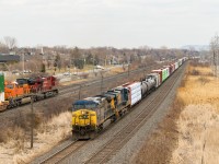CN 327 with CSXT 532 & CSXT 5424 is heading west on CN's Kingston Sub just as CP 142 with CP 8803 & BNSF 3999 passes on CP's Vaudreuil Sub.