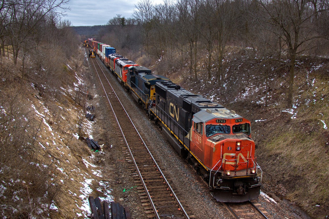 My original intention was to try to shoot by the curve at York Road, though I quickly realized that wasn't going to happen with CN MOW equipment hard at work on the south track. With some luck, the tie gang was positioned just right for a fairly open shot of CN 148's power further east. According to a local, CN had been working on tie replacements in the area since the weekend. All the ties with tie plates painted orange were replaced soon after this photo, with the majority of the track gang still extending beyond the curve at this point.

Thanks to those who gave the heads up, I was aware of 148's lashup to make it down to Hamilton. For power here is CN 5745, GECX 9135 (ex CSX 7334, nee CR 6138), CN 5507, CN 5519. The SD60F's were along for the ride dead in tow, and with them now off the roster, it is presumed they are headed for scrap. The probability is fairly high they're destined for K&K Recycling in Pickering like the previous five that came through. Those were noted for looking quite fresh, as if they were recently outshopped from GMDD in London. The same could be said for these two, especially 5507. It's quite remarkable how well the paint has held up after nearly thirty years, while the lead SD75I (and many other 75I's) is peeling away with the red dried out, barely exceeding twenty years of age.

Due to the track work, CN 148 is down to around 10-15mph with the dynamic brakes groaning, blaring the horn as required. It escaped my mind to grab my earplugs, and being on a bridge right above where the horn would pass under, concern ran through my mind. The crew, however, momentarily stopped sounding the horn when approaching the bridge. Courtesy measures like this are greatly appreciated.

Hamilton West is only a half mile east of this location, but I figured I would try a little uphill. I certainly can't understate this spot. It's a nice peaceful footbridge away from traffic. Not sure how well it would work for lighting on a sunny day, but on a dreary day for eastbounds, it's a good alternative with the Niagara Escarpment providing a backdrop to remove most of the overcast lighting.