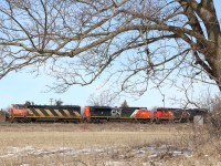 The temperature is finally reading double digits as we near the end of April. The last of the snow has yet to melt as CN train 435 rolls through the dormant scenery at Stewartown just west of Georgetown. 