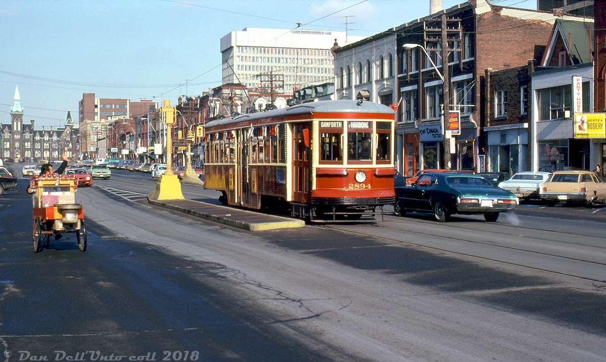 A passing street vendor gives a wave to TTC Peter Witt streetcar 2894, stopped along the busy Spadina Avenue at Nassau Street amid traffic and storefronts lined with numerous fashion, fabric and textile retailers (that helped the area become known as the "Fashion District"). The prominent 1 Spadina Crescent is visible in the background.

TTC 2894 was one of two Peter Witts used for the new Beltline Tour Tram service started in 1973: car 2766 had been retained after the Peter Witt fleet was retired in the mid-60's, and 2894 was acquired back by the TTC (previously stored in a barn near Barrie). Both were rebuilt and restored at Hillcrest Shop, and later joined by Witt 2424 loaned back by the Halton County Radial Railway.

The Beltline Tour Tram service (just looping around a few main downtown streets for the same fare as a regular car) ran seasonally in 1973 and 1974, and after being discontinued by the TTC due to low ridership it was handled by a private operator for a few years after. The three Witts were also often chartered and ran on private fantrips around the city. Today 2894 and 2424 reside at the HCRY streetcar museum in Rockwood, while 2766 is kept by the TTC for special events and fantrips.

J. Bryce Lee photo, Dan Dell'Unto coll.