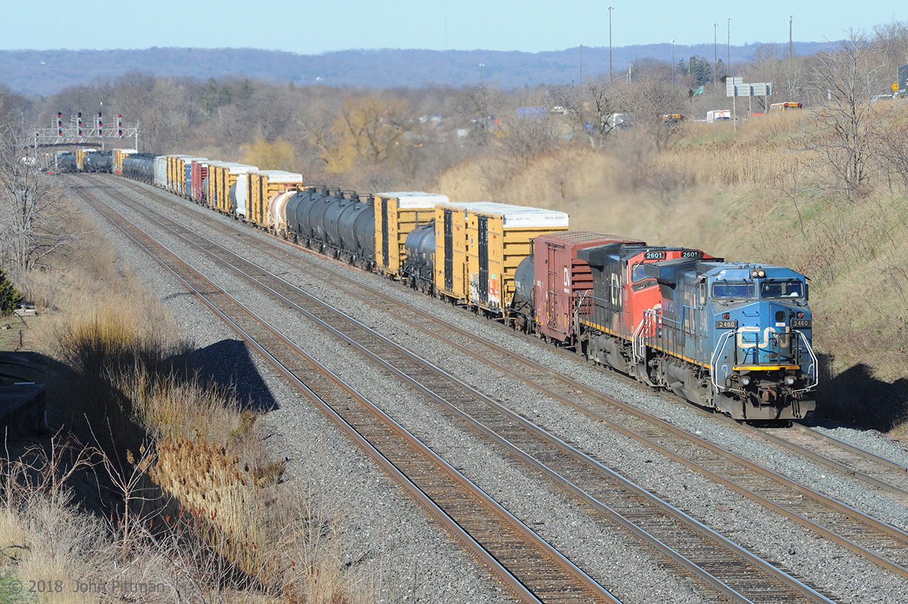 GE Dash 8 IC 2460 in ex-LMSX Conrail blue (aka C40-8W) together with Dash 9 CN 2601 drag train CN 422 upgrade through the CN Snake (Road) crossovers and into Aldershot Yard using the west yard lead.  Passing though the yard works better when the cars to be dropped are on the tail end, as in this case. 
This train further along its journey -  http://www.railpictures.ca/?attachment_id=33111