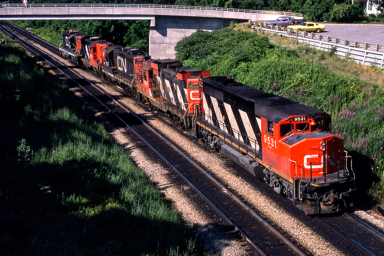 CN 9531 is part of a power move passing under the pedestrian bridge just north of Bayview Junction on July 24, 1980.