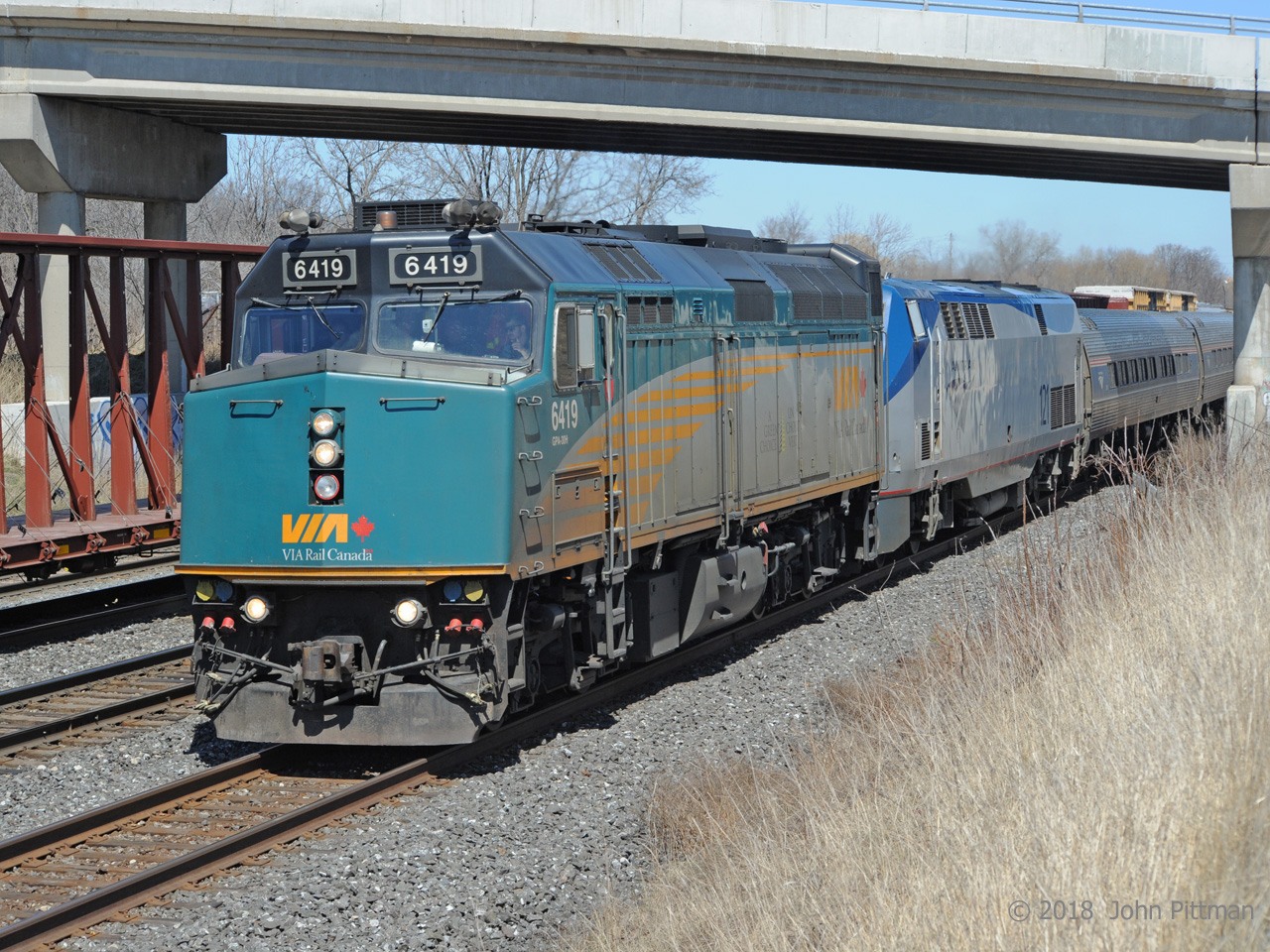 VIA 6419 leads defective AMTK 121 and train VIA 97 / Amtrak 64 at 2:18 PM, running about five and a quarter hours late at this point.  Congestion on the Oakville and Grimsby subs in Hamilton and beyond (CN freights 550 and 421 are ahead) would cause further delays.   Remarkably, it is making its third pass under Lemonville Road bridge this afternoon - photos taken from the bridge confirm that AMTK 121's diesel engine was running, perhaps providing head end power.  
The train had previously been down to the next control point, CN Snake (Road), waiting there for opposing train CN 422 to clear.  It was a surprise when VIA 97 reversed back to Aldershot Station for a brief stop.  My sympathies to the passengers.  
More about this off-schedule train can be found at:  http://www.railpictures.ca/?attachment_id=33078