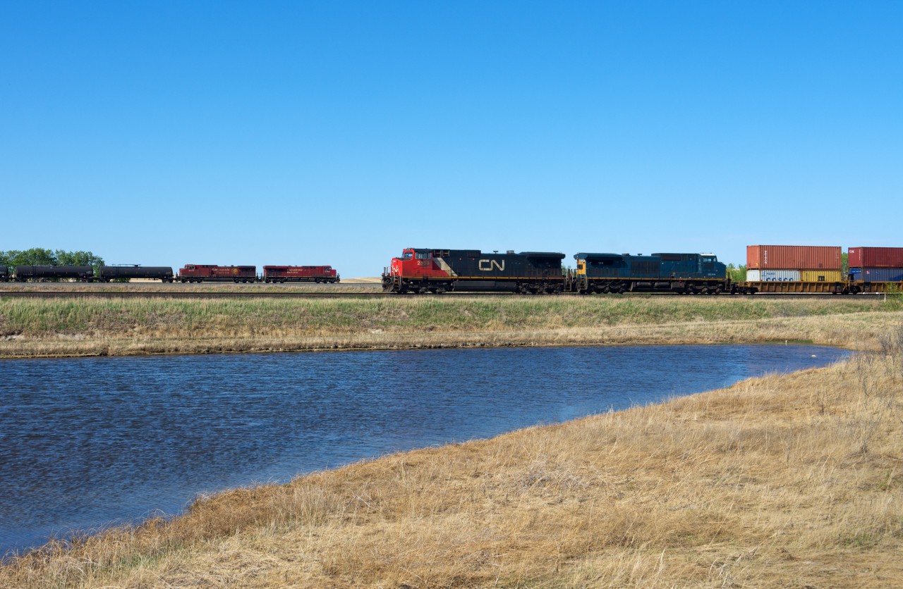 CN 105 is seen holding the main east of the siding at Neola. It is one of four trains stopped in the area as Biggar experiences some good old gridlock. In the background CP 8709 east fly's by at track speed, but it is about to encounter significant delays of it's own.