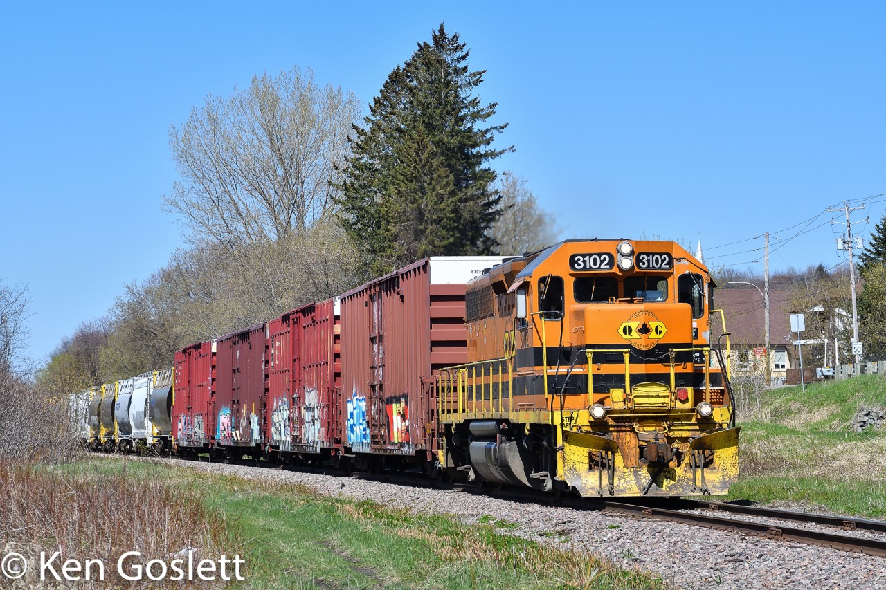 With twenty cars in tow QG 3102 rounds the curve at Pointe-au-Chene, Quebec.