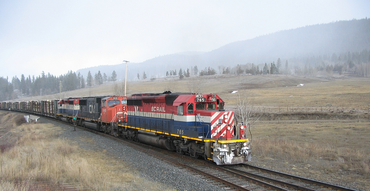 In a snow flurry, train 570 arrives at Mackin with a few more miles left before a crew change at Williams Lake BC. It was an interesting power consist with BCOL 765, CN 5648 and BCOL 758. A few railfans chased this train the next morning on the Squamish sub account the 765 leading. Also note the car loads of logs behind the units, this would be aspen / poplar logs destined for the "oriented strand board" plant in 100 Mile House.
