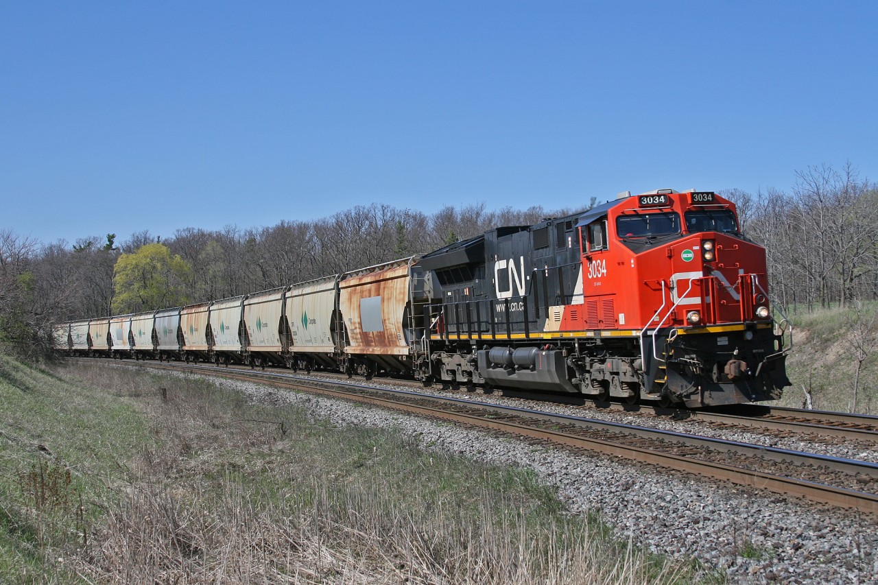 CN B 78131 07, rolls westwards down the Halton Sub with CN 3034 on the point and CN 2968 as the mid train DP unit.  This 209 car unit train of Potash empties is bound for Yarbo, Saskatchewan and originated in Moncton, New Brunswick as B 73111 06.  Originally planned to operate over the more direct route through Northern Ontario, the symbol was changed to 781 at Belleville to allow it to detour south of the Great Lakes due to congestion in Northern Ontario.