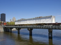 A piece destined for the new Champlain Bridge in Montreal is crossing the bridge over the Lachine Canal, destined for the Port of Montreal, with a second just behind. From there the bridge pieces will reach the work site via barge. 