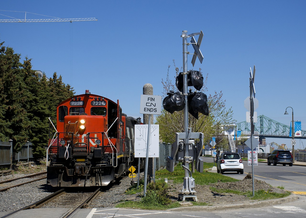 A transfer led by CN 7226 is sitting at the western end of Port of Montreal trackage, where it becomes the CN Wharf Spur. It cannot leave until security is in place to flag the many crossings in this area, but soon new crossing gates (an unfinished one is seen here) will render the flagging unnecessary.