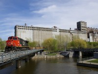 CN 564 with repainted BCOL 4647 as sole power is entering the Port of Montreal with a long string of baretables. Behind the train is the out of use grain elevator #5.