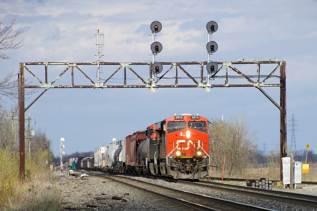 CN X321 with a pair of ES44AC's slowly approaches Coteau Yard where he will lift more cars. He is passing under a classic signal bridge just past the turnoff for the Valleyfiel Sub.