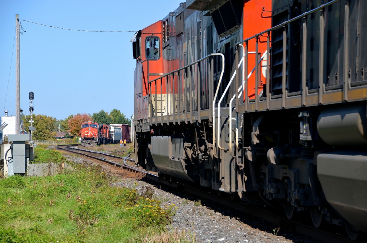 CN 401 with CN 2287 leading is in the hole at Saint-Léonard-d'Aston for CN 310, which is bound for Joffre Yard with CN 2641 leading. CN 401's crew is out to give a roll-by to the passing train.