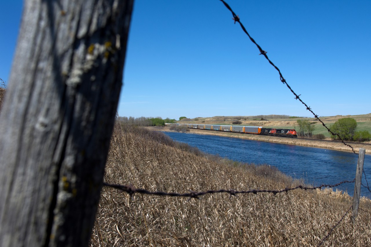 CN 8957 and 5785 hustle train 308 eastbound though a nice spring scene just east of Biggar SK.