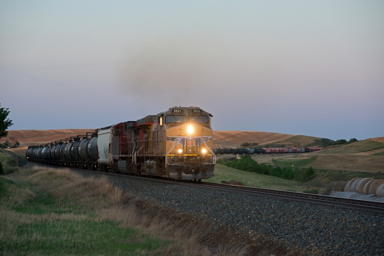 FPSK?.... It doesn't have the same ring to it.   UP 5521 is on the point of a westbound on CP's Wilkie sub just east of Biggar SK along side the CN siding named Neola. The time is 21:02.