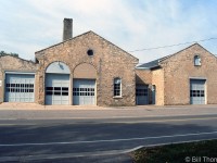 The former Guelph Railway Company streetcar barns at 371 Waterloo Ave. are pictured in October 1998. The building was built in 1895 by brewery owner John Sleeman to provide streetcar service for his employees. The city purchased the street railway in 1903, and the streetcars were eventually replaced by buses in 1937. The building was then used as a bus garage for the Guelph Transportation Commission until the 1970's, and saw use by various small businesses (used by Edwards Collision at the time of the photo). It was eventually converted to residential apartments by J. Lammer Developments Ltd., and is presently known as the "Greystone Residences" (more information <a href=https://www.guelphmercury.com/living-story/2779849-flash-from-the-past-old-guelph-bus-barns-now-hold-apartments/><b>here</b></a>).
