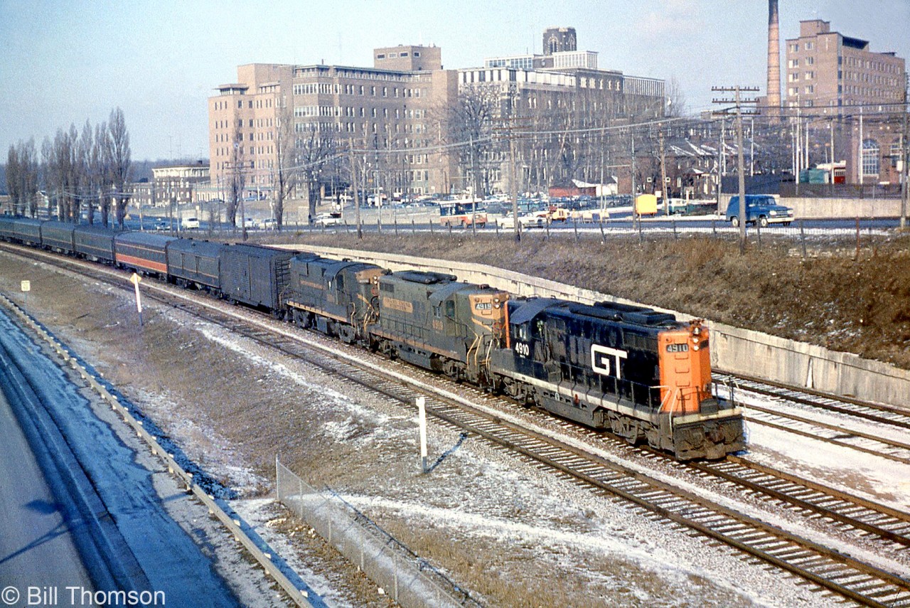 CN train #14 (Chicago-Montreal) is shown pulling in to Sunnyside Station around 9 AM one sunny morning in 1962. Power is GTW GP9's 4910 (in the new red and black CN/GTW noodle livery) and 4919, plus a CN RS18. Note the Illinois Central coach from the US behind head end cars.