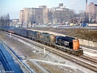 CN train #14 (the Chicago-Montreal "International Limited") is shown pulling in to Sunnyside Station around 9 AM one sunny morning in 1962. Power is GTW GP9's 4910 (in the new red and black CN/GTW noodle livery) and 4919, plus a CN RS18. Note the Illinois Central coach from the US behind head end cars.