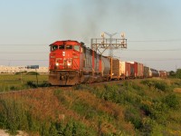 CN SD60F 5523 and a sister lead an eastbound manifest towards MacMillan yard in Toronto after meeting train 149 at Mansewood on the Halton Subdivision during a clear summer evening. 