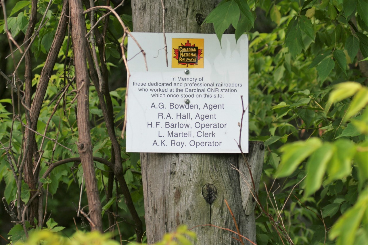 Down a dirt road that leads to the CN Kingston Subdivision and placed on a pole is a fitting historical tribute to those that once worked at the site of the former Canadian National Cardinal station.