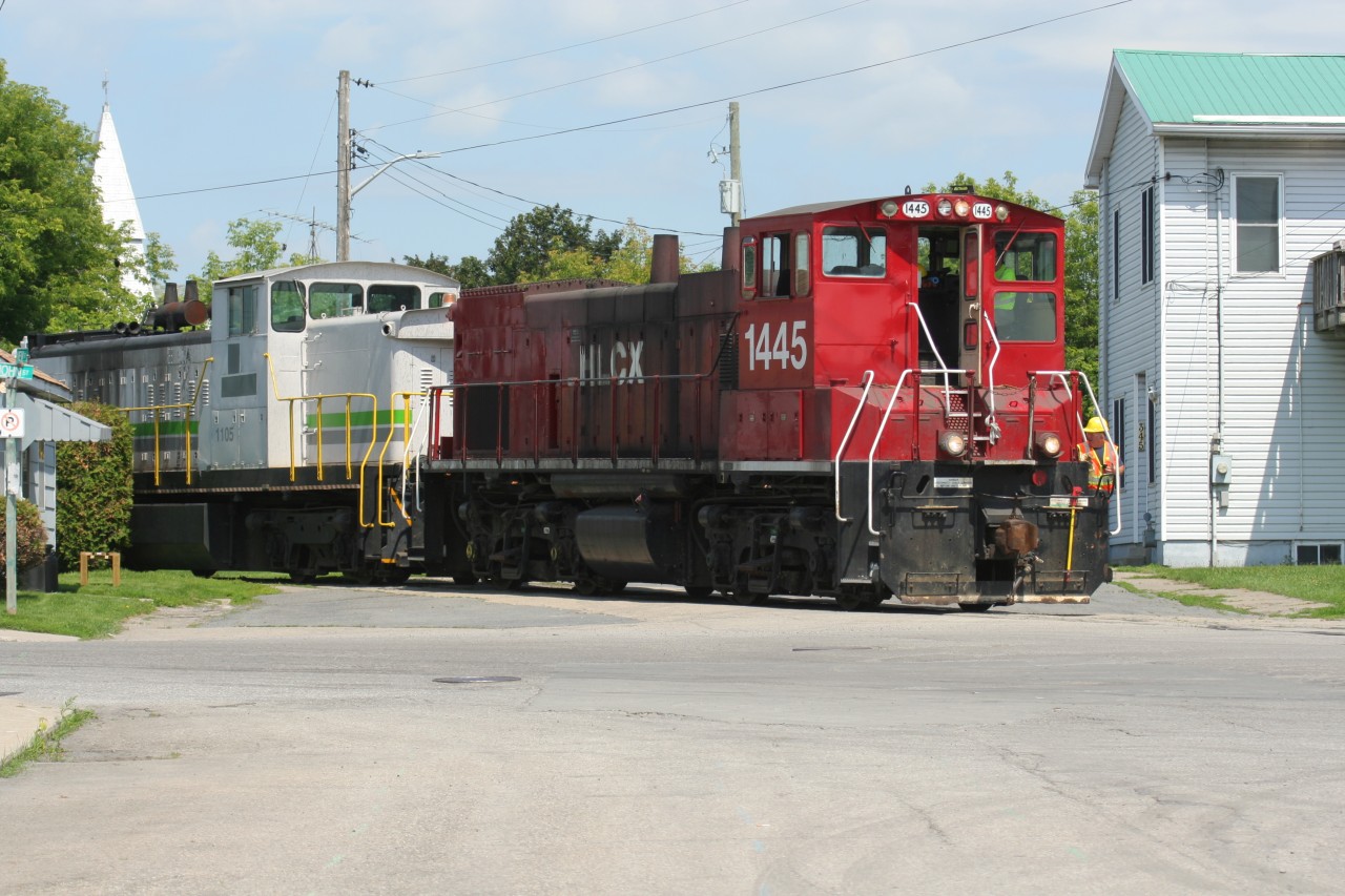 During June 2015, a friend and I ventured to the small eastern Ontario town of Cardinal. Here, Ingredion Canada operates a 1.5 mile industrial spur that connects its former Canada Starch Company (CASCO) facility to the CN Kingston Subdivision at mile 104.8. The Ingredion Canada railway crews make several daily runs between their small interchange with CN beside the Kingston Subdivision and the large plant. The spur offers some neat views as it meanders through Cardinal, crossing several streets and even running closely beside some businesses and houses. In the town, near the water tower and just north of Highway #2, Ingredion Canada has a three-track support yard where it stores cars. This yard is located between the interchange with CN and the Ingredion Canada facility. 

Helm Financial Corporation (HLCX) ex-Canadian Pacific MP15AC 1445 and ex-CN GMD-1 1105 are seen slowly rolling through Cardinal as they bring three tank cars to the Ingredion Canada plant.