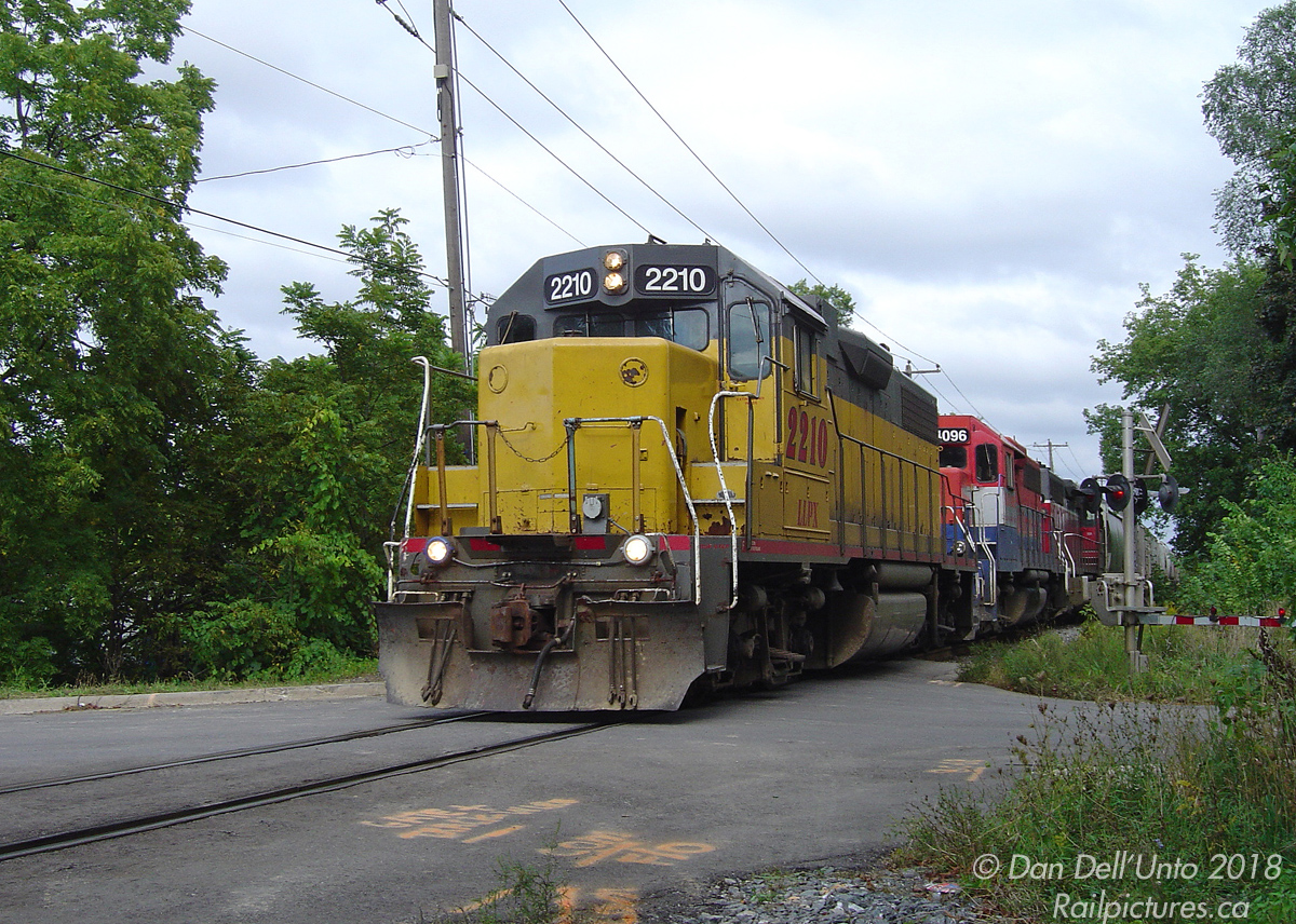 Back when GEXR was just a rag-tag fleet of secondhand and leased 4-motor EMDs, we find leased LLPX GP38 2210 teamed up with GEXR GP40's 4096 & 4019 handling the daily #431, with their train lifted from CN's MacMillan Yard, running the single-track gauntlet between Brampton East and Peel (seen at the dual James/John Street crossings) as they make their way back to home rails at Georgetown. Back when this segment was single track, the CN RTC always had an uphill battle juggling westbound and eastbound freights through here, while at the same time trying to keep the evening rush-hour Georgetown GO trains and VIA #87 from getting delayed.Today the CN Halton Sub through here is double-tracked, "Brampton East" is no more (Peel interlocking moved to the west), the brush has been cleared back, James St. crossing has been closed to traffic and removed (John St. crossing remains), and most of the power usually on GEXR #431/432 are 6-motor SD's (the GEXR itself is on borrowed time, as CN plans to take back operations of the line in the near future).