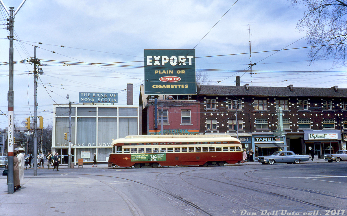 TTC A-11 class PCC 4640 (a secondhand ex-Cleveland car) heads westbound on Bloor Street at the very top of Spadina Avenue, as pedestrians go about enjoying their Saturday. The green ad on 4640 advertises the new West Toronto Towers (at 103 West Lodge Avenue). Passengers on the left wait for a northbound Spadina bus to head up Spadina Road, as this section of Spadina was only in use by the Harbord streetcar between Dundas and Harbord. In the background, a row of storefronts house the Bank of Nova Scotia, Varsity Restaurant, Super 'NN' Market, Tamblyn drugs, and Diplomat dry cleaning. There are no rails here today as the streetcars on this part of Bloor were nixed a year after this photo when the new Bloor Danforth subway line opened between Keele and Woodbine in February 1966, and the present Spadina streetcar line ducks into a tunnel underneath this intersection to service the underground Spadina subway station streetcar loop. But the storefronts in the background still exist today, retaining much of their original appearance (albeit with different tenants with the exception of Scotiabank - still in the same building over 50 years later).Original photographer John F. Bromley (or possibly Robert McMann), Kodachrome from the Dan Dell'Unto collection.