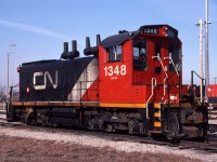 Not many of CN's SW1200RS got repainted with the 1993 scheme, but CN 1348 is one of them. Yard engines got the 1993 CN North America scheme minus the grey continent. However mainline locomotives did not receive the continent emblem either after 1995. <br>
The way I heard it, not enough people recognized the (slightly stylized) outline of the North America continent, while quite a few thought that the emblem was the result of black paint peeling off.