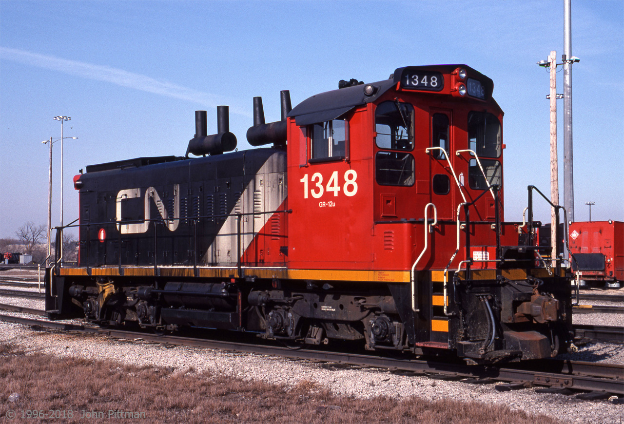 Not many of CN's SW1200RS got repainted with the 1993 scheme, but CN 1348 is one of them. Yard engines got the 1993 CN North America scheme minus the grey continent. However mainline locomotives did not receive the continent emblem either after 1995. 
The way I heard it, not enough people recognized the (slightly stylized) outline of the North America continent, while quite a few thought that the emblem was the result of black paint peeling off.