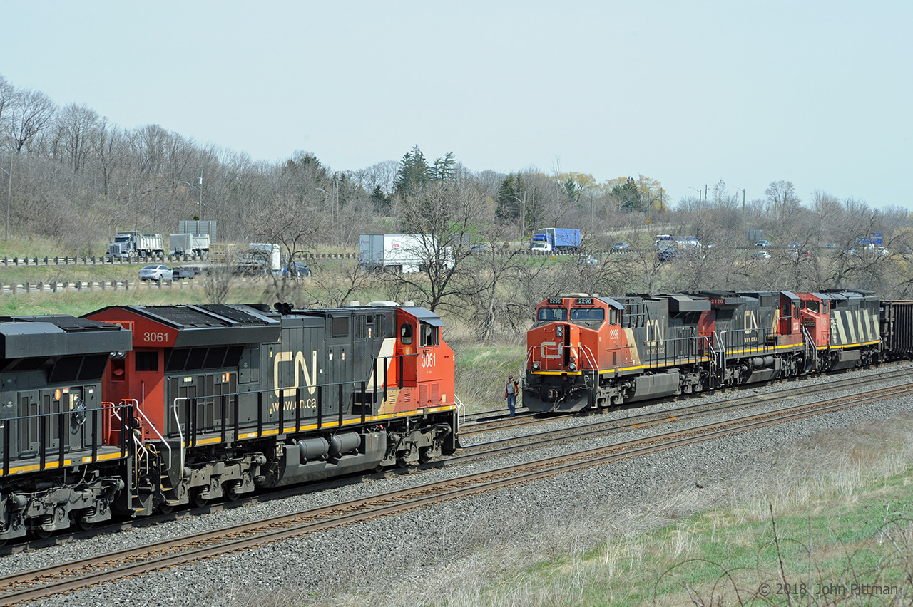 CN 421 with head end units CN 2296 (ES44dc), CN 2126 (C40-8), and CN 2406 (C40-8cowl) and midtrain CN 2106 (C40-8) is ready to proceed to Port Robinson when it gets its signal at CN Snake.  That will be after CN 148 powered by CN 3061 (ET44ac) and CN 2866 (ES44ac) has cleared.  A crewman from 421 is positioned to make a roll-by inspection of train 148.