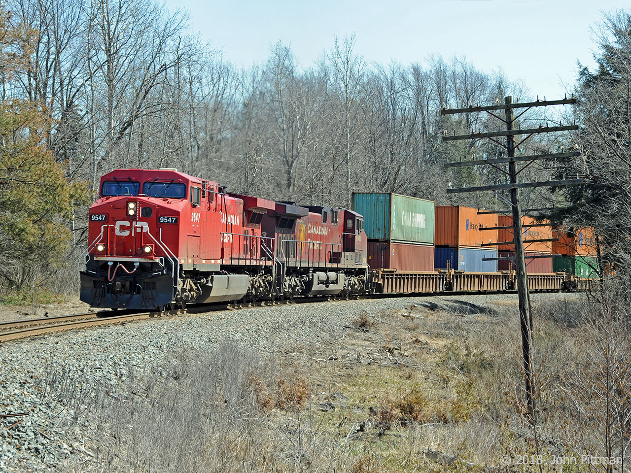 CP 9547 (AC4400cw) and CP 8603 (AC4400cw), both equipped with GE steerable trucks, are pulling train CP 142  upgrade north on the CP Hamilton sub with the assistance of pusher set CP 2211, CP 7307, CP 2292. The front end is seconds away from the Parkside Drive grade crossing in Waterdown North. A few miles ahead the train will have completed the steepest part of the ascent from Lake Ontario level to Lake Erie level.  The pushers will cut off and return light to Hamilton, while 142 continues to CP Guelph Junction and beyond. 
CP 9547 is from CP's original 1995 batch of AC4400's that began CP's change from an SD40-2 dominated railway.  These 9500's were not equipped with steerable trucks when new, and were delivered in the CP Rail System dual flags scheme which proved unpopular on both sides of the border.