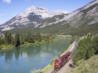 The last train of an all to short western visit approaches Exshaw along the Bow River