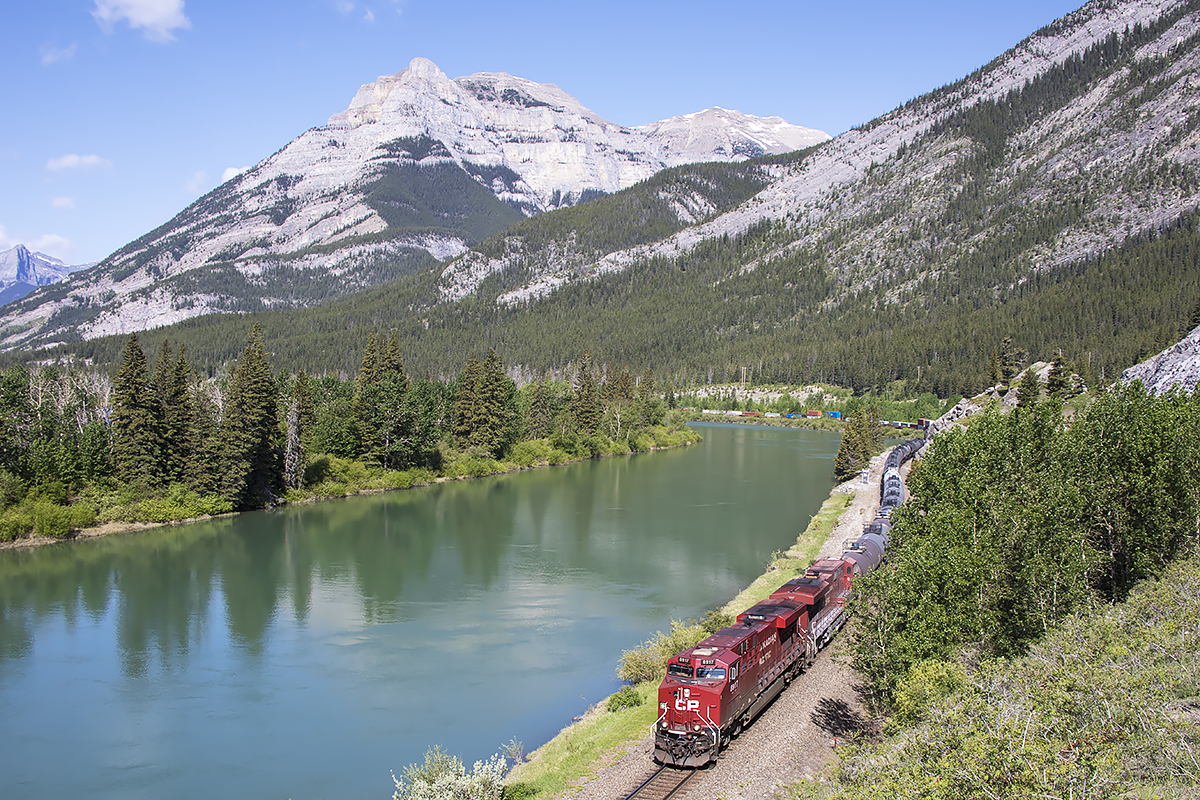 The last train of an all to short western visit approaches Exshaw along the Bow River