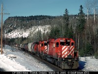 CP 5863, one of CP's last few large multimark scheme units left at the time, leads a train dubbed "Q-ARM" by the lineup, near Fire Hill, Ontario back on March 15, 2005.  This train is moving a large Canadian Forces Unit to BC for training, but as you can see by the picture, CP decided to add in a large cut of empty grain hoppers ahead of the Military equipment as part of the move paid for by our Canadian Tax dollars.  