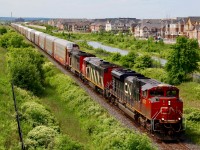 It has been interesting over the years documenting the changes to the urban sprawl in Milton. This view only a few years ago was farmers fields up to Derry Road although this shot then wasn’t possible as the Louis Saint Laurent bridge didn’t exist. The block of new homes on the right are almost complete and soon the country view in the opposite direction may look more like this one. Here we see CN train 435 with a three unit lash up in three different paint schemes. The slight zig-zag in the distance marks the location where the original at grade right of way left the new grade separation built in the 1960s.