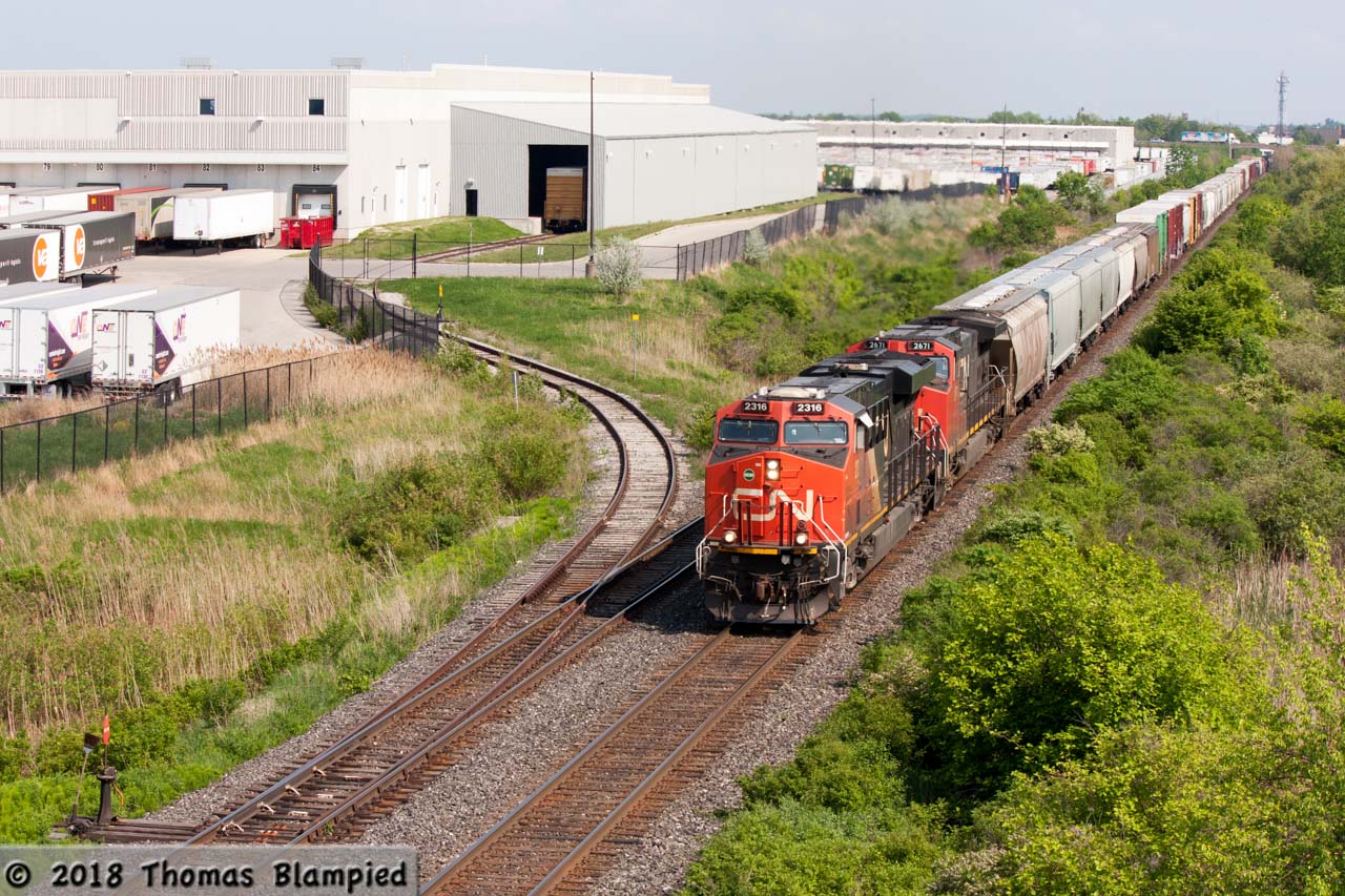 CN 2316 and 2671 pass the Whirlpool plant on their way to Mansewood.