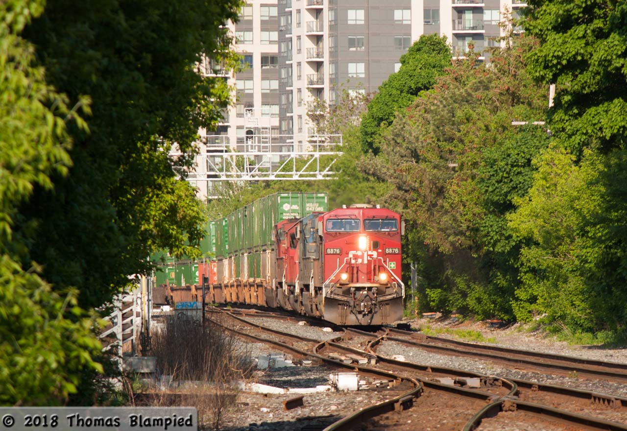 Through a canyon of tower blocks and trees, a yard transfer crosses over at Osler on its way to the Mactier Sub with 8876 leading CEFX 1037 and CP units 6223 and 9658.