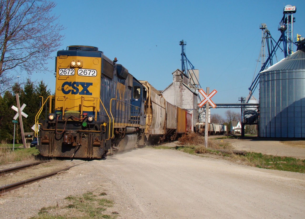 After dropping 5 hoppers and lifting 2 from the elevator behind, CSX local D724 accelerates west out of Tupperville at 15:29hrs heading towards Wallaceburg where he'll drop the head end hopper. Then, the slow trek back to Sarnia begins, arriving there after dark. The day started at 08:00 when the local departed Sarnia with 35 cars, 29 of which were bound for the SouthWest CO-OP in Wallaceburg.