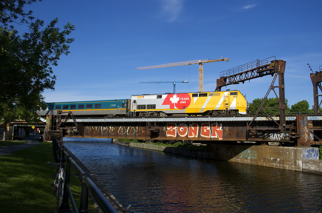 VIA 916 has a lager 'VIA 40' wrap on its long hood than other similarly wrapped VIA Rail P42DC's and here it leads VIA 22 over the Lachine Canal in Montreal.