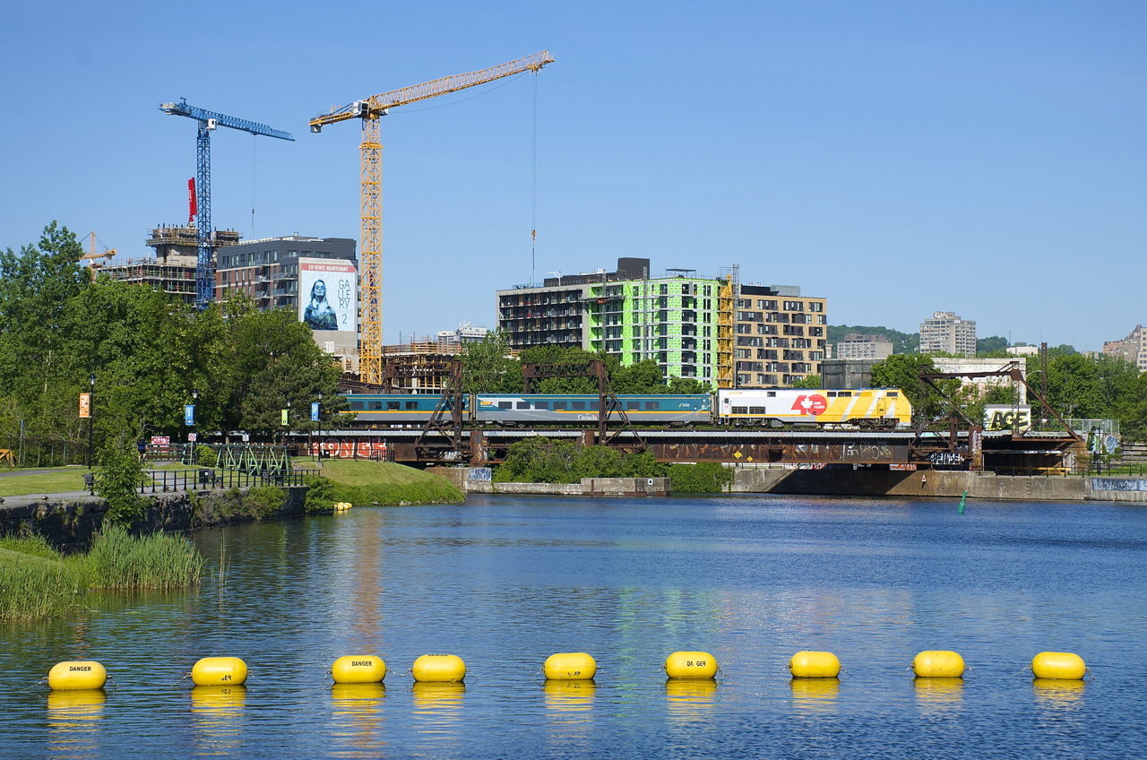 With cranes in the background helping to construct even more condo's, VIA 33 with VIA 909 leading passes the Peel Basin on its way to Central Station in Montreal.