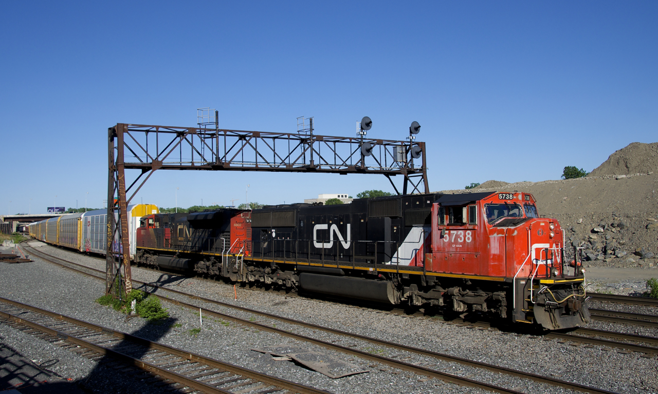 CN 401 with CN 5738 & CN 8802 lead CN 401 under a classic signal bridge which is living on borrowed time. Already signals have been removed over the transfer and freight track at left, those over the north and south track at right are sure to follow. At left is a track leading to what will be CN's new right of way in the near future.