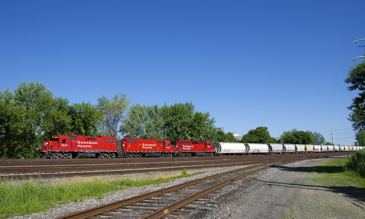 CP F94 is comprised of CP 3024, CP 4428 & CP 2205 and 22 cars as it passes the Lasalle Yard, on its way to serving clients on the Lacolle Sub on a gorgeous morning.