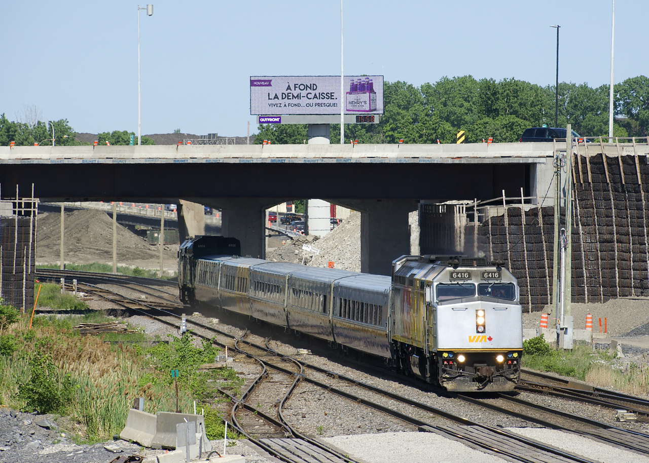 VIA 67 has wrapped VIA 6416 leading and unwrapped VIA 6404 with five LRC cars in between as it passes Turcot West.
