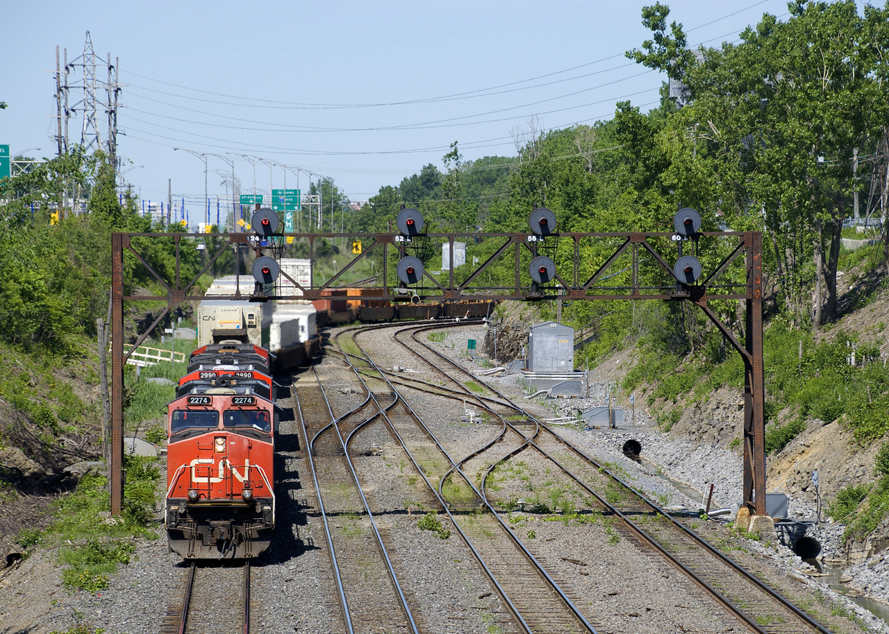 CN 120 has a trio of gevo's (CN 2274, CN 2990 & CN 2969) up front and CN 8937 mid-train as it exits Taschereau Yard after setting off and lifting cars in the yard.